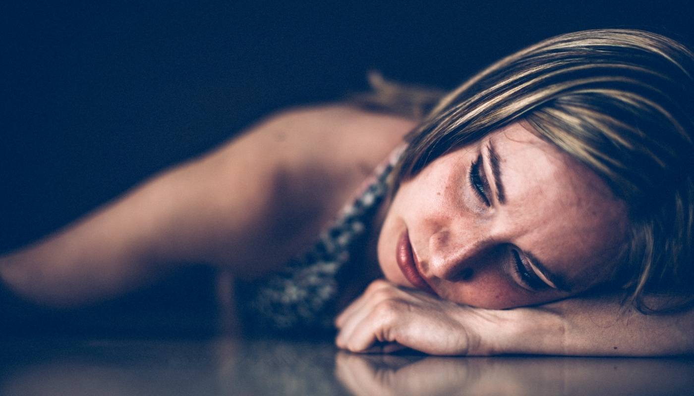 Blonde-haired teenager who self-harms is laying on the floor